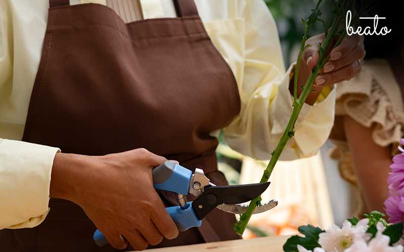 Florist cutting the stems of flowers