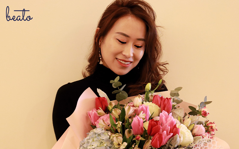 smiling woman looking at flowers