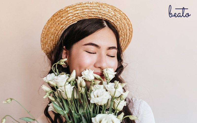 woman smelling flowers looking happy